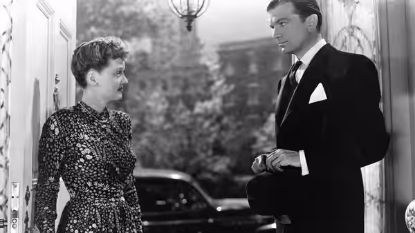 Charlotte (Bette Davis) and Jerry (Paul Henreid) talk beside a parked car