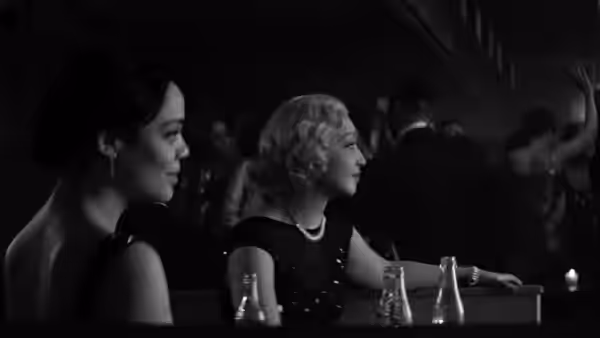 Irene Redfield (Tessa Thompson) and Clare Kendry (Ruth Negga) sit at a table in a crowded venue