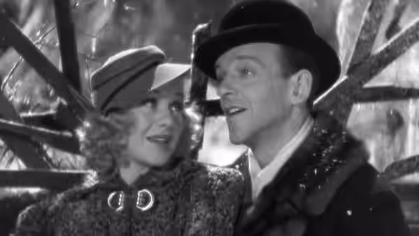Lucky Garnett (Fred Astaire) and Penny Carrol (Ginger Rogers) stand close beneath a glass canopy