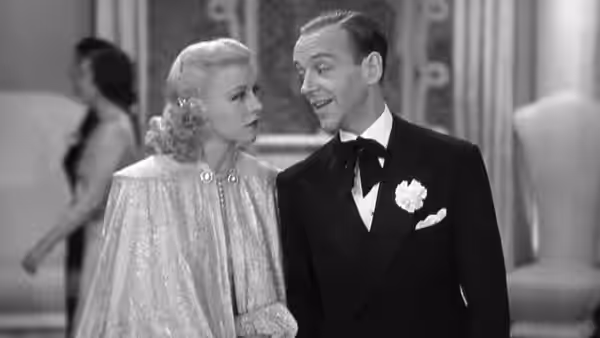 Penny Carrol (Ginger Rogers) and Lucky Garnett (Fred Astaire) stand together in a hallway