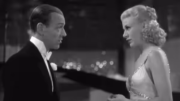 Lucky Garnett (Fred Astaire) faces Penny Carrol (Ginger Rogers) across a dance floor