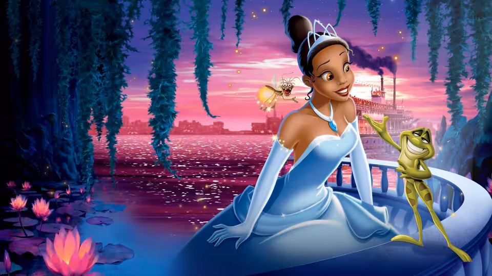 Tiana (Anika Noni Rose) in a blue gown on a boat with frog Naveen at dusk