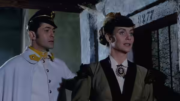 A uniformed officer and a formally dressed woman stand together in a doorway
