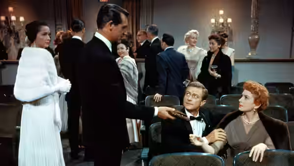 Nickie Ferrante (Cary Grant) speaks with Kenneth Bradley (Richard Denning) and Terry McKay (Deborah Kerr) in a lounge