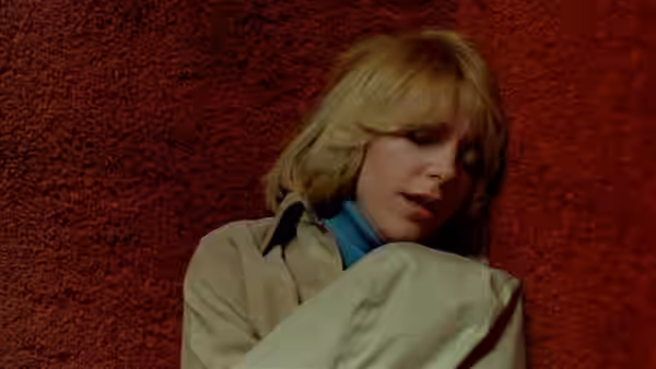 Francine (Gaylen Ross) leans against a red textured wall