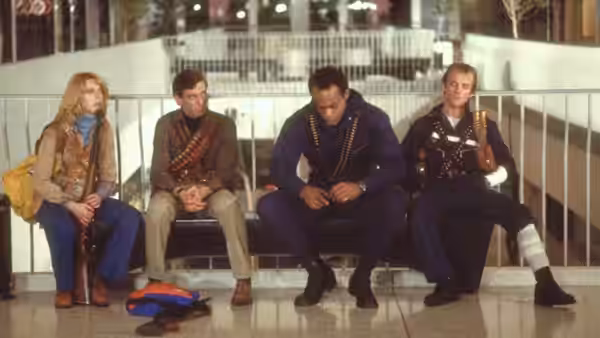 Francine (Gaylen Ross) sits with three men on a mall bench