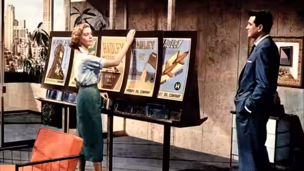 A woman presents display boards to a suited man in an office