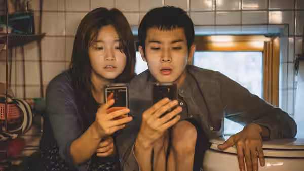 Young man and woman sitting on a toilet using smartphones