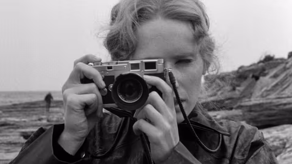 Elisabet Vogler (Liv Ullmann) raises a camera beside the sea