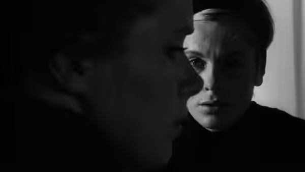A woman looks past the dark profile of another person