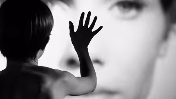 A child raises a hand toward a woman's enormous face