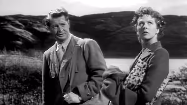 Joan Webster (Wendy Hiller) and Torquil MacNeil (Roger Livesey) stand beside a loch