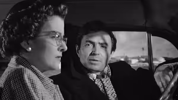 Lucia Harper (Joan Bennett) sits beside Martin Donnelly (James Mason) in a car