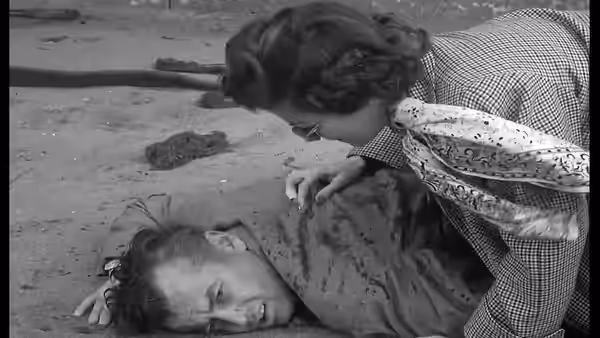 Lucia Harper (Joan Bennett) bends over a man lying on the ground