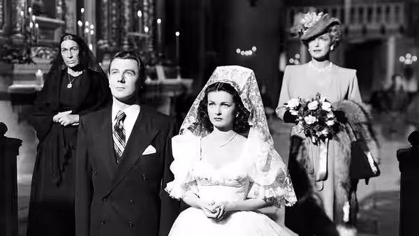 Celia Lamphere (Joan Bennett) sits in her wedding dress beside Mark Lamphere (Michael Redgrave)