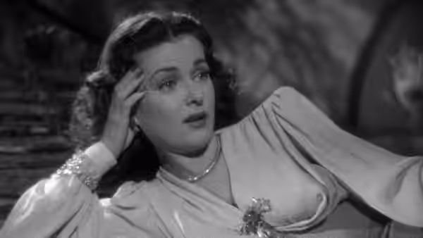 Celia Lamphere (Joan Bennett) reclines with one hand at her temple