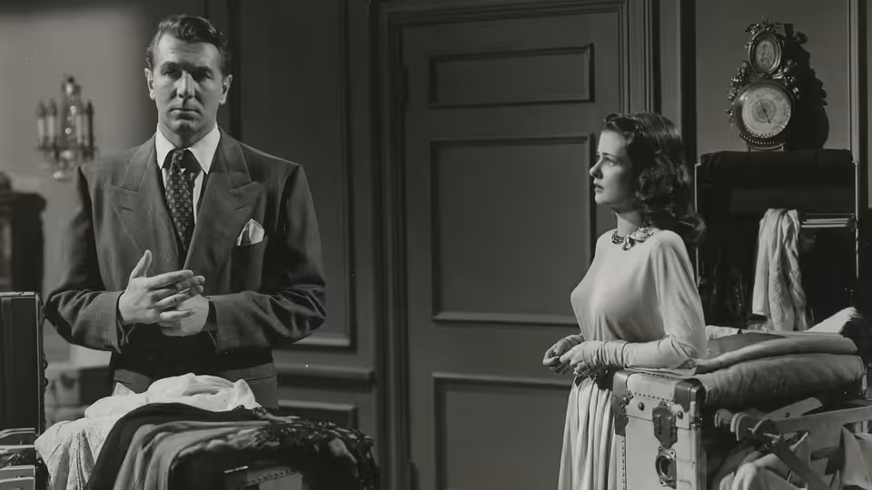 Mark Lamphere (Michael Redgrave) stands beside a bed as Celia Lamphere (Joan Bennett) watches