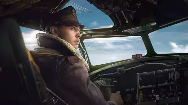 A flight crewman sits at the controls inside a bomber cockpit