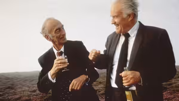 Jackie O'Shea (Ian Bannen) and Michael O'Sullivan (David Kelly) celebrate with drinks on a hillside