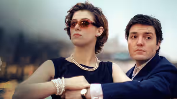Julie (Honor Swinton Byrne) and Anthony (Tom Burke) standing together outdoors at night