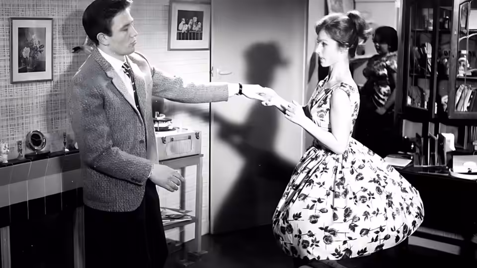 Arthur Seaton takes Doreen's hand in a café