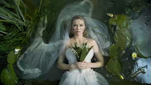 Justine (Kirsten Dunst) floating in a pond wearing a wedding dress