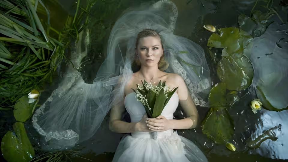 Justine (Kirsten Dunst) floating in a pond wearing a wedding dress