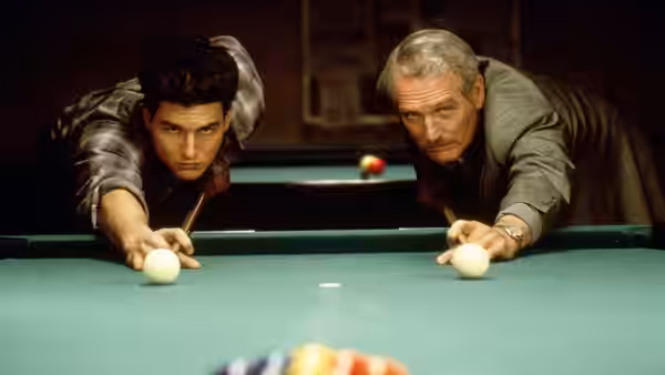 Vincent Lauria (Tom Cruise) and Eddie Felson (Paul Newman) lean over opposite sides of a pool table