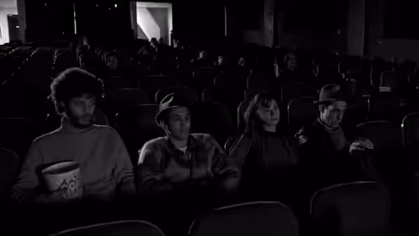 Willie (John Lurie), Eddie (Richard Edson) and Eva (Eszter Balint) sit in a cinema