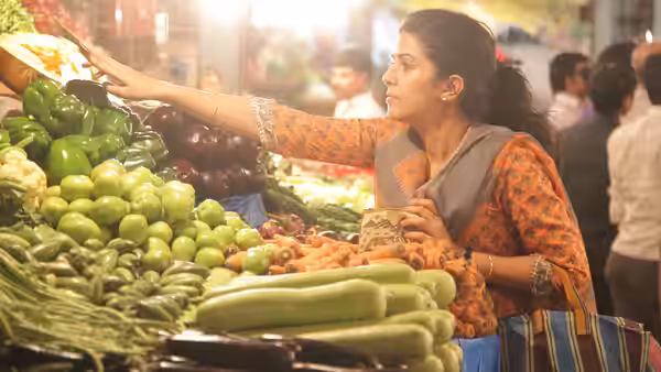 Ila (Nimrat Kaur) selects vegetables at a busy market stall