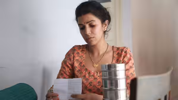 Ila (Nimrat Kaur) reads a note beside a stacked metal lunchbox