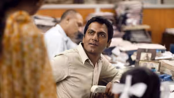 Shaikh (Nawazuddin Siddiqui) looks up from his desk in a crowded office