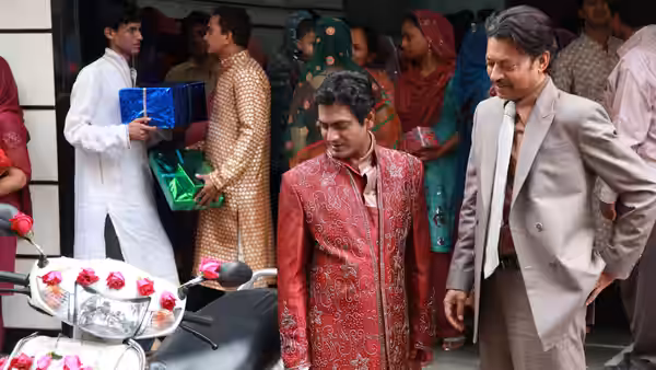 Shaikh (Nawazuddin Siddiqui) and Saajan Fernandes (Irrfan Khan) walk past guests at a wedding