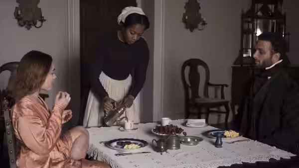 Katherine Lester (Florence Pugh) watches Anna (Naomi Ackie) pour tea as Sebastian sits at the table
