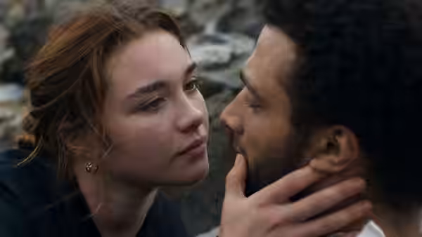 Katherine Lester (Florence Pugh) cups Sebastian's face beside a rocky stream