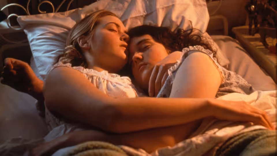 Juliet (Kate Winslet) and Pauline (Melanie Lynskey) embracing in bed