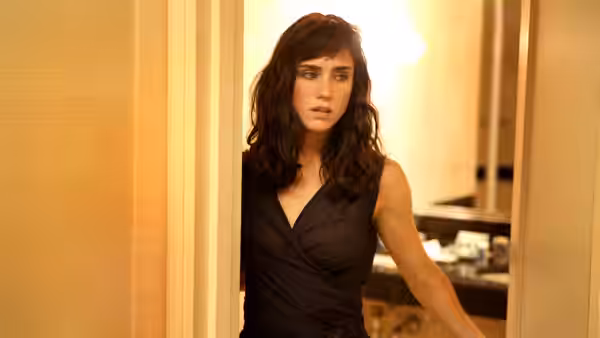 Kathy Adamson (Jennifer Connelly) peers through a doorway into a bathroom