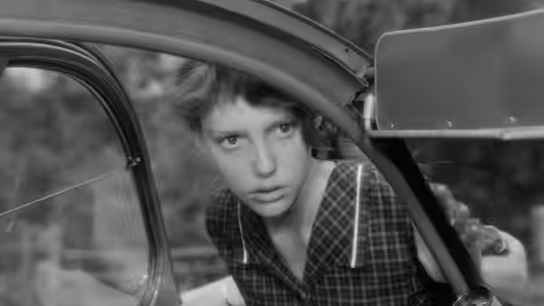 Marie (Anne Wiazemsky) leans through the open window of a car