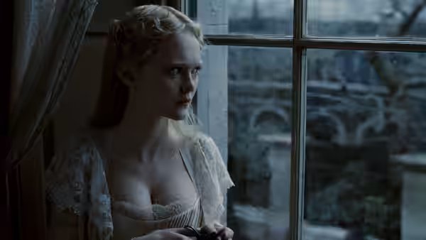 Johanna (Jayne Wisener) gazing out of a window in a white dress