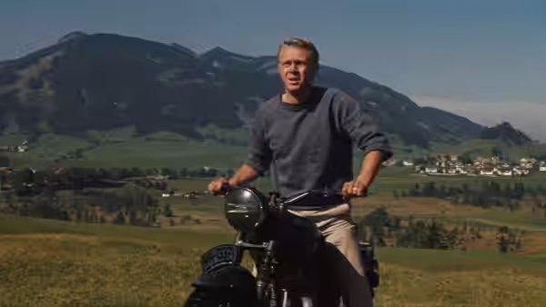 Hilts (Steve McQueen) riding a motorcycle through a mountainous valley