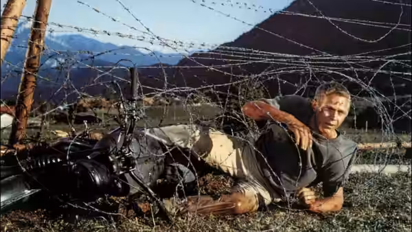 Hilts (Steve McQueen) caught in barbed wire beside his motorcycle