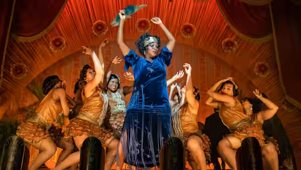 Ma Rainey (Viola Davis) raises a feathered fan as dancers move around her onstage