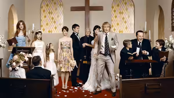 John Beckwith (Owen Wilson) stands among the wedding party inside a church