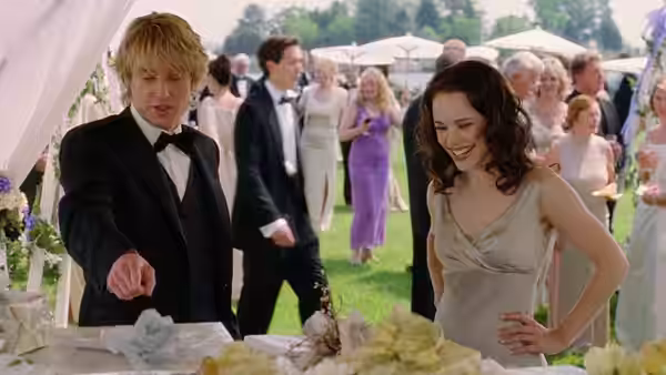 John Beckwith (Owen Wilson) and Claire Cleary (Rachel McAdams) smile over a wedding cake