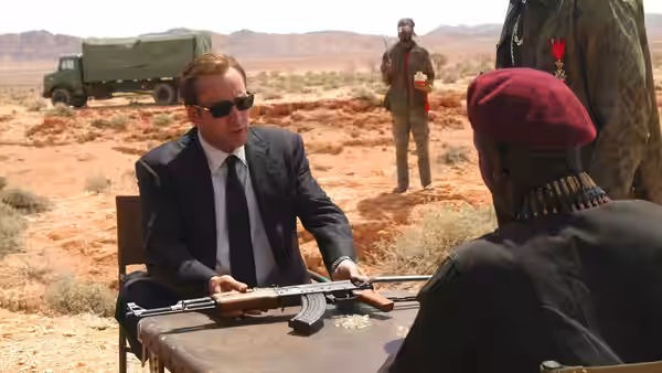 Yuri Orlov (Nicolas Cage) displays a rifle across a table to an African officer