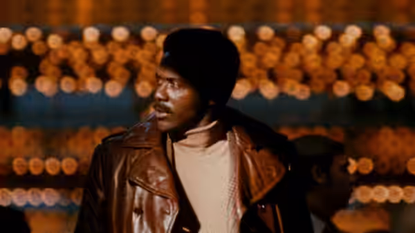 John Shaft (Richard Roundtree) looks aside beneath rows of glowing lights