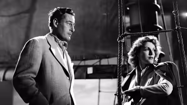 Wesley Rand (James Ellison) stands beside Betsy Connell (Frances Dee) near a ship's rigging