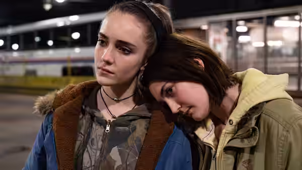 Skylar (Talia Ryder) stands at a station as Autumn (Sidney Flanigan) leans against her