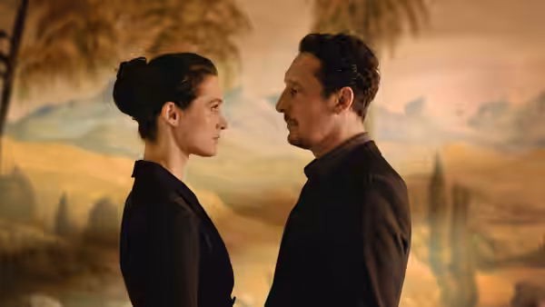 Lisa Konrad (Friederike Becht) facing Robert Lenzen (Hans Löw) before a painted mural