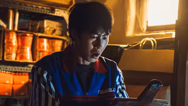 Byeon Hyuk-joon (Lee Jae-wook) examining a tablet in a cluttered storage room